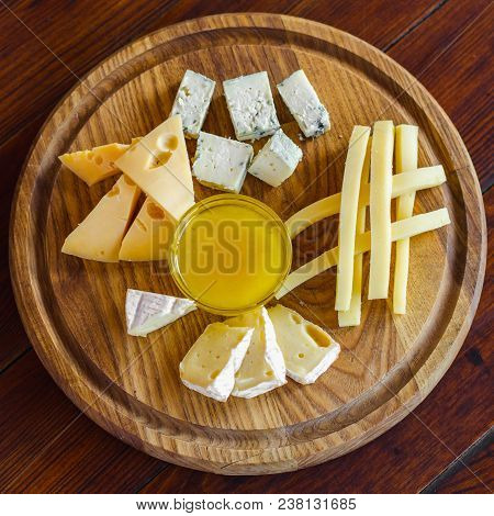 Cheese Plate. Assortment Of Various Types Of Cheese On Wooden Cutting Board.