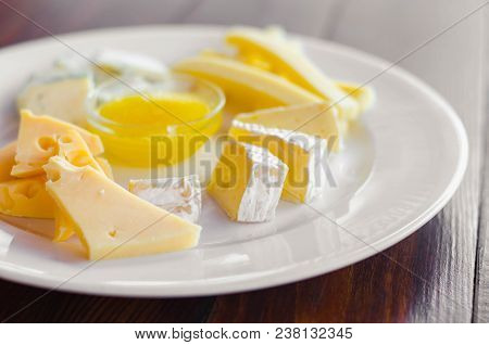 Cheese Plate. Assortment Of Various Types Of Cheese On Wooden Cutting Board.