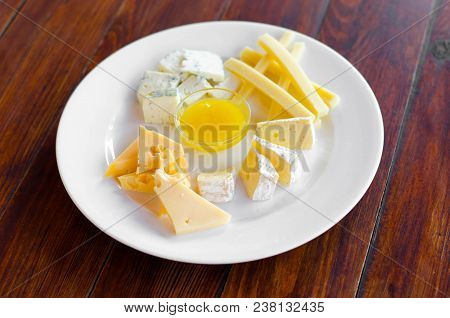 Cheese Plate. Assortment Of Various Types Of Cheese On Wooden Cutting Board.