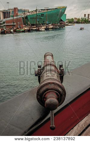 Amsterdam, Northern Netherlands - June 25, 2017. Old Iron Cannon Mounted On Wooden Sailboat Bulwark 