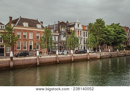 Dordrecht, Southern Netherlands - June 30, 2017. Wide Tree-lined Canal With Brick Buildings In A Str
