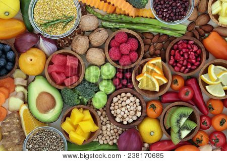 Health food selection with fresh vegetables, fruit, herbs, pulses, seeds and nuts. Super foods concept  very high in antioxidants, fibre, smart carbohydrates, anthocyanins and vitamins.