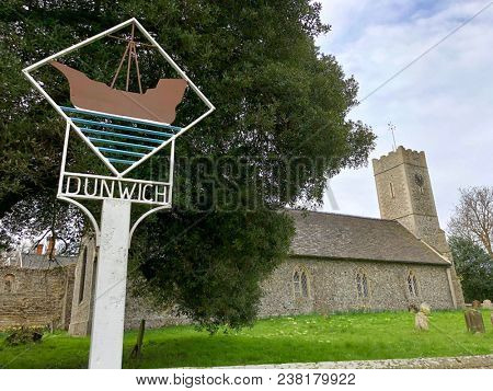 DUNWICH, SUFFOLK - APRIL 24, 2018: Village sign beside St James Church the in the village of Dunwich, Suffolk, UK.