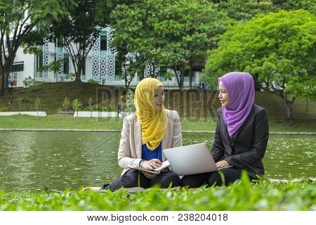 Portrait Of Young Lovely Pleasant Mix Ethnic Woman Sitting On Grass At Summer Green Park And Having 