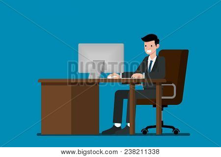 Happy Businessman Working On A Personal Computer, Sitting On A Brown Leather Chair Behind The Office