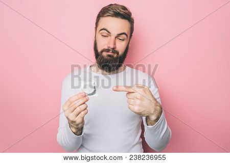 Guy Is Holding A Condom Is His Hands And Pointing On It. He Cares About His Protection. Isolated On 