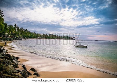 Mirissa Beach, Sri Lanka - JAN 3, 2017:  Tourist walking on the sand while enjoying the view across the wonderful beach in sunset of Mirissa on Jan 3, 2017. Sri Lanka.