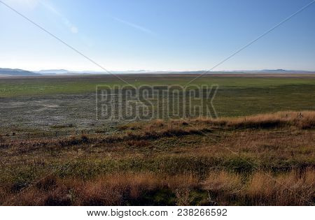Empty Lake George Nestled Between A Rural Wind Farm And Farmland In Australia. Lake George Is An End