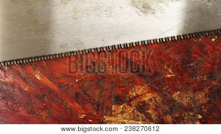 Saw Lies On Dirty Workbench In Carpentry Workshop. Tool For Manual Labor