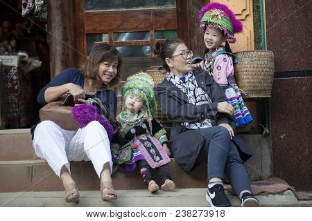 Sapa Laocai Vietnam - Nov3,2017 : Asian Tourist Sitting On Town Street Beside Hill Tribe Children Of