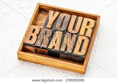 your brand word abstract in letterpress wood type in a wooden boc against textured white paper