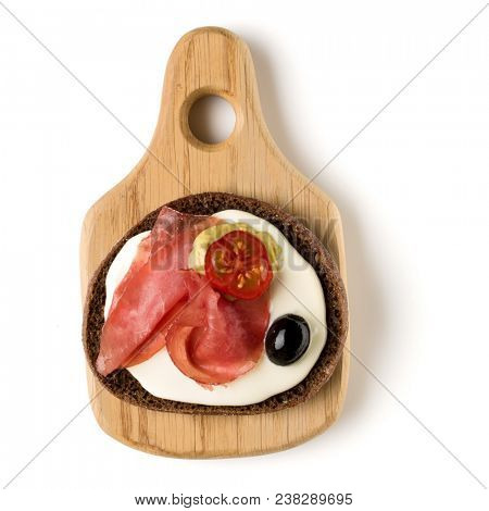 Open  faced sausage sandwich canape or crostini on a wooden serving board  isolated on white background closeup. Top view.