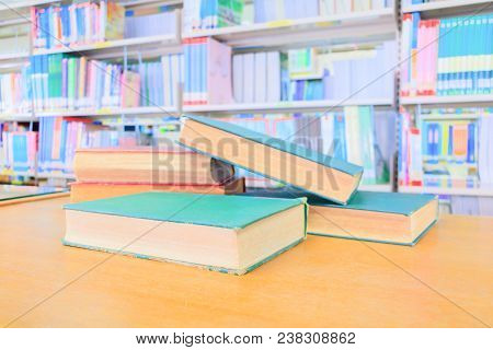 Old Book Red - Green. And Heap Treatise In School Library On Wooden Table.  Blurry Bookshelves Backg