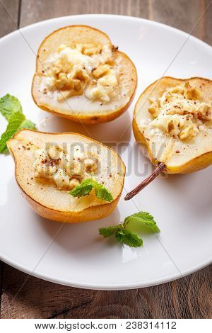 Pears Baked With Ricotta Cheese, Nuts, Honey And Cinnamon On Rustic Wooden Background