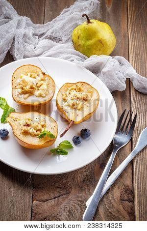 Pears Baked With Ricotta Cheese, Nuts, Honey And Cinnamon On Rustic Wooden Background