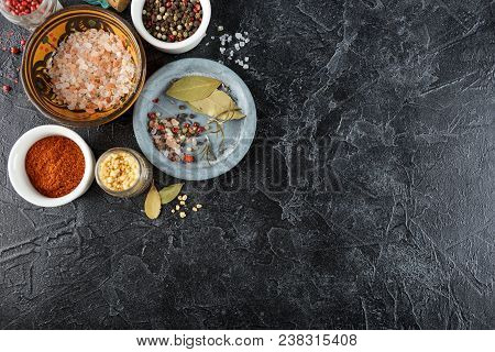 Pink, Gold And White Salt, Black And Red Peppercorns, Bay Leaf, Paprika On A Black Background Top Vi