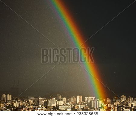 Amazing bright rainbow over city, picturescue beautiful view on the multicolored wonder of nature in rainy weather in the town, Lebanon