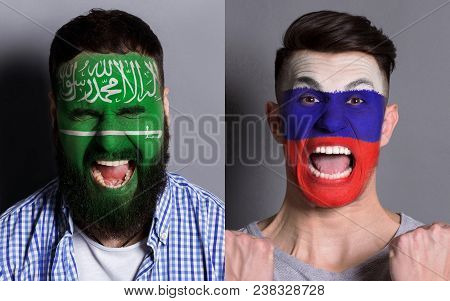 Emotional Soccer Fans With Painted Saudi Arabia And Russia Flags On Faces. Confrontation Of Football