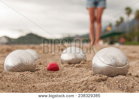 Beach. A Game Of Bocha. Brilliant Silver Balls For A Bocha On The Sand.