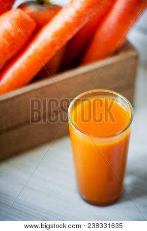 Photo Of Fresh Carrots In A Wooden Box And A Glass Of Freshly Squeezed Carrot Juice