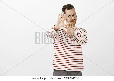 Portrait Of Displeased Picky Aduly Man With Bristle, Pulling Palms Towards Camera In No Or Stop Gest
