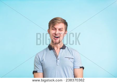 Young Fool Guy Making Grimace Isolated On Blue Background