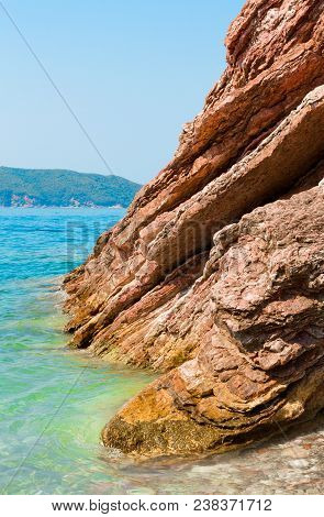 Scenic Layered Rocks In The Sea. Rafailovici. Montenegro. Beautiful Nature Vertical Wallpaper