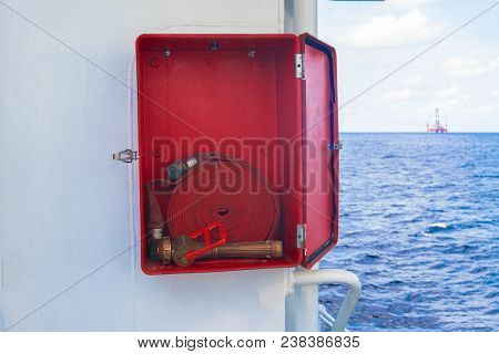 Fire Prevention Onboard Vessel At Sea. Fire Cabinet With Fire Equipment And International Fire Sign.