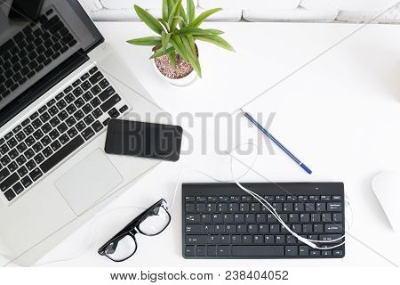 Close Up Gedgets On Workplace White Desk With Laptop And Smartphone