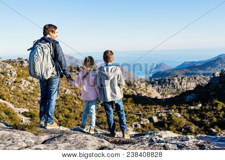 Family father and his two kids enjoying breathtaking views of Cape Town from top of Table mountain