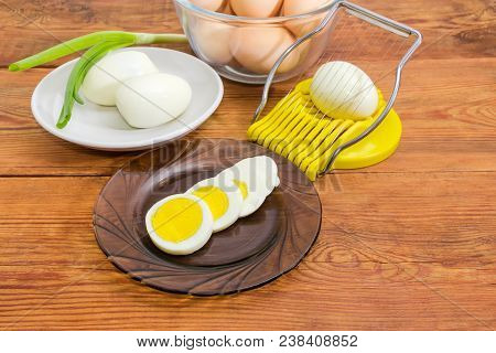 Partly Sliced, Peeled And Not Cleaned Boiled Eggs In Different Dishes And Egg Slicer With Egg In It 