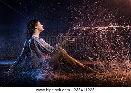 Girl In The White Shirt With Water Drops And Dark Walls Background Illuminated By Colored Light Duri