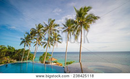 Outdoor Swimming Pool In A Tropical Country Philippines With Palm Trees. Evening Time.