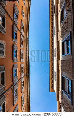 Top Of The Facades Of Typical Milan Street Against Blue Sky. Architectural Background Concept