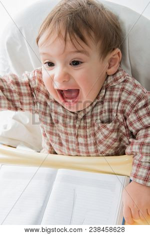 Little baby boy is playing with pen and note book