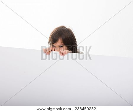 Little Caucasian Boy peeking behind White Boards