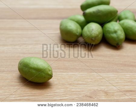 A Group Of Green Hog Plums Fruit, Which Look Like Small Mango, Over Bright Wooden Background With Co