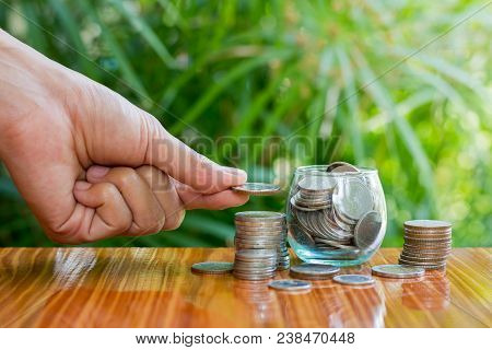 Women Hand Put Money Coins To Stack Of Coins. Business Growth Concept.