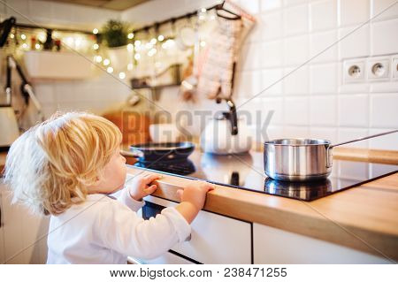 Toddler Boy In A Dangerous Situation At Home. Domestic Accident. Child Safety Concept.