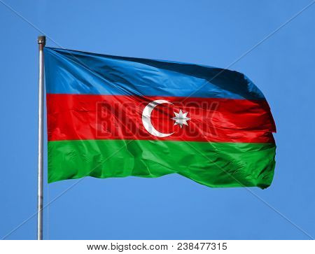 National Flag Of Azerbaijan On A Flagpole In Front Of Blue Sky.