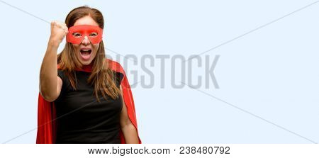 Middle age super hero woman wearing red mask and cape irritated and angry expressing negative emotion, annoyed with someone isolated blue background