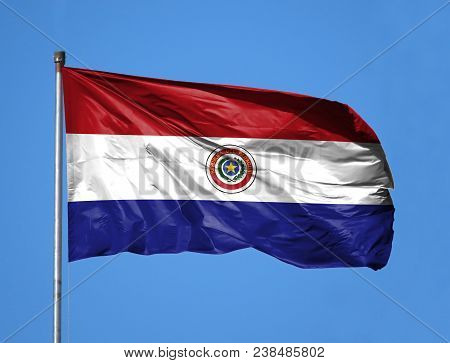 National Flag Of Paraguay On A Flagpole In Front Of Blue Sky.