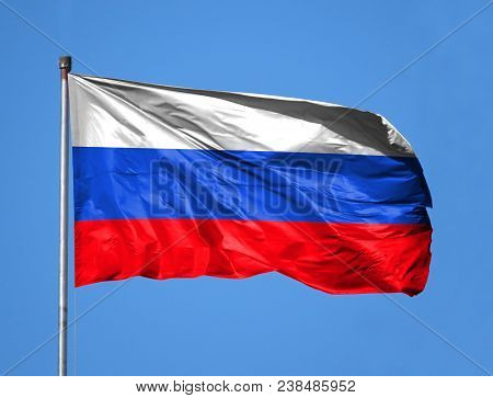 National Flag Of Russia On A Flagpole In Front Of Blue Sky.