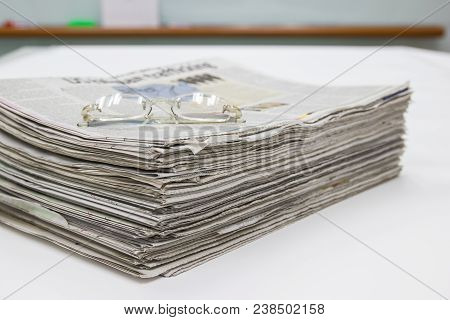 Closeup - Newspaper Stack On White Table In Office
