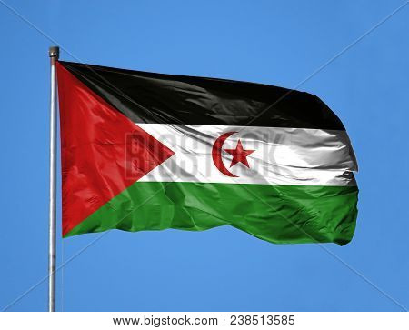 National Flag Of Western Sahara On A Flagpole In Front Of Blue Sky.