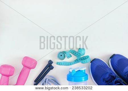 The Sports Equipment Is On The Bottom On An Empty Light Background. Classes Of Fitness. A Layout Wit