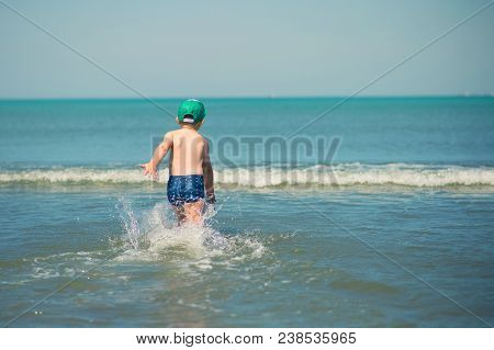 Littl Boy Is Running Along The Beach Playing And Splashing In Water Of Adriatic Sea In Durres, Alban
