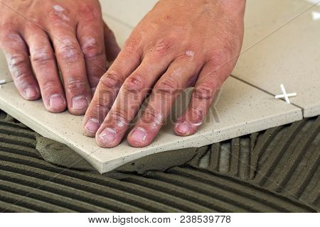 Ceramic Tiles And Tools For Tiler. Worker Hand Installing Floor Tiles. Home Improvement, Renovation 