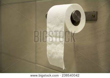 Close-up Of White Soft Tissue Paper Roll In Bathroom, Restroom, Wc On Light Brown Beige Tiling Backg