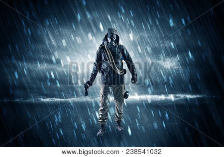 Terrorist in a stormy space with gas mask on his hand and weapons on his arm